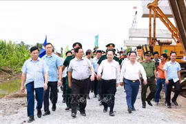 Prime Minister Pham Minh Chinh (second from left) and officials examine the construction site at Highway 61C intersection in Hau Giang Province’s Phung Hiep district on July 13 (Photo: VNA)