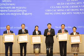 Chairman of the Vietnam-Laos Friendship Association (VLFA) Central Committee Nguyen Dac Vinh (third, right) presents the Friendship Order to 15 members of the Laos-Vietnam Friendship Association (LVFA) Central Committee (Photo: VNA)
