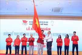 Vietnamese Minister of Culture, Sports and Tourism Nguyen Van Hung presents a flag to the Vietnamese team (Photo: VNA)