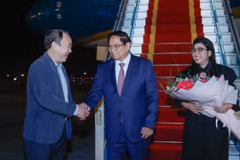 Prime Minister Pham Minh Chinh (C) and his spouse are welcomed by Vice Chairman of the Government Office Nguyen Sy Hiep at the Noi Bai International Airport. (Photo: VGP)