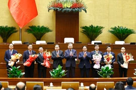 Party General Secretary To Lam (C), Prime Minister Pham Minh Chinh (4th from right) and NA Chairman Tran Thanh Man (4th from left) congratulate the newly-appointed ministers and justices of the Supreme People's Court. (Photo: VNA)