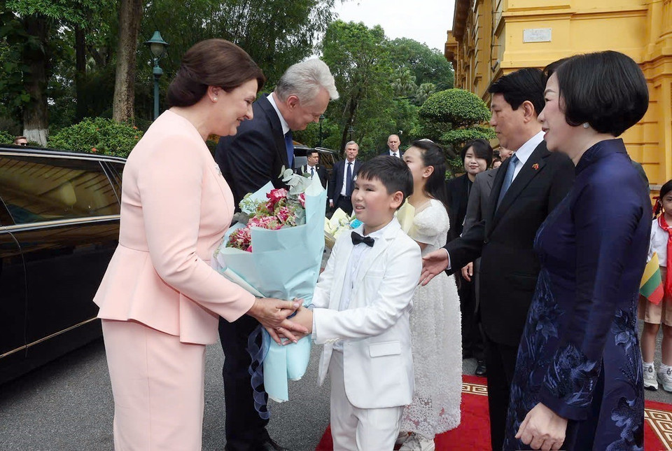 Children of Hanoi present flowers to Lithuanian President Gitanas Nauseda and his Spouse. (Photo: VNA)