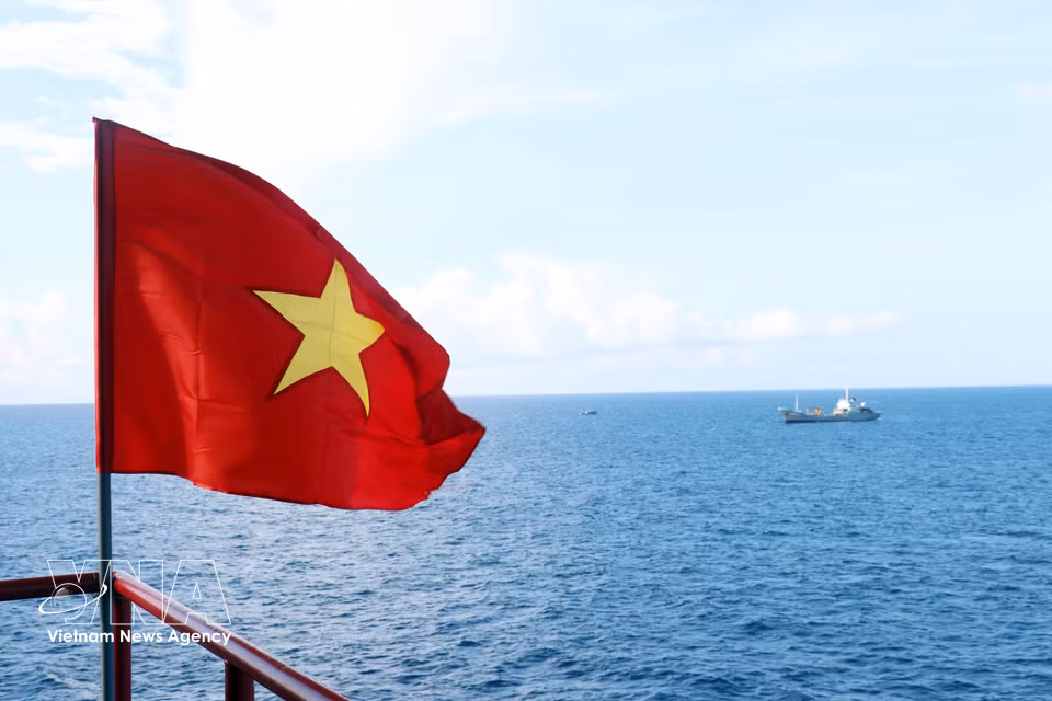 The national flag flies over the Que Duong Economic, Scientific and Technical Service Station (DK1/8 platform). (Photo: VNA)