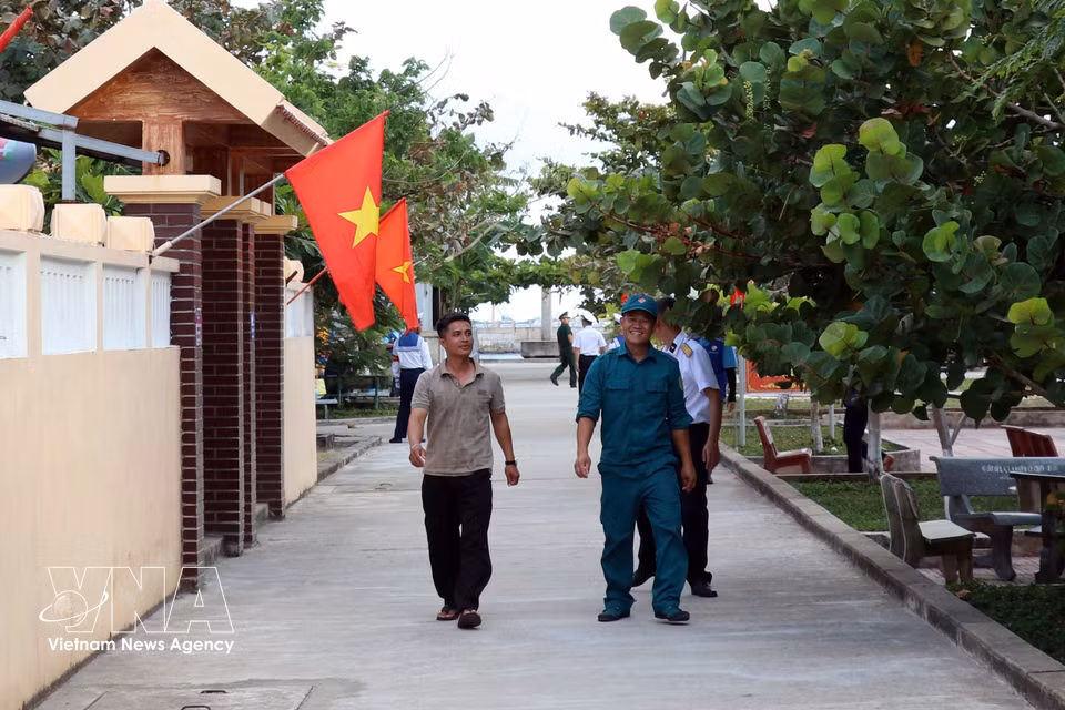 The red flag with a yellow star brightens the front yards of homes on Da Tay A Island. (Photo: VNA)