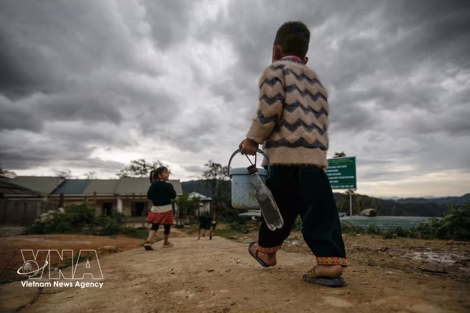 From Monday to Friday, Grade 1 and Grade 2 pupils in Lang Sang hamlet regularly carry lunch boxes and drinking water to school. (Photo: VNA)