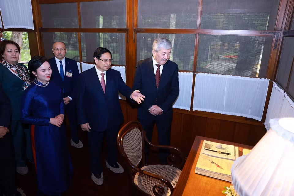 Prime Minister Pham Minh Chinh introduces his Kyrgyz counterpart Adylbek Kasymaliev to the living and working space of President Ho Chi Minh. (Photo: VNA)