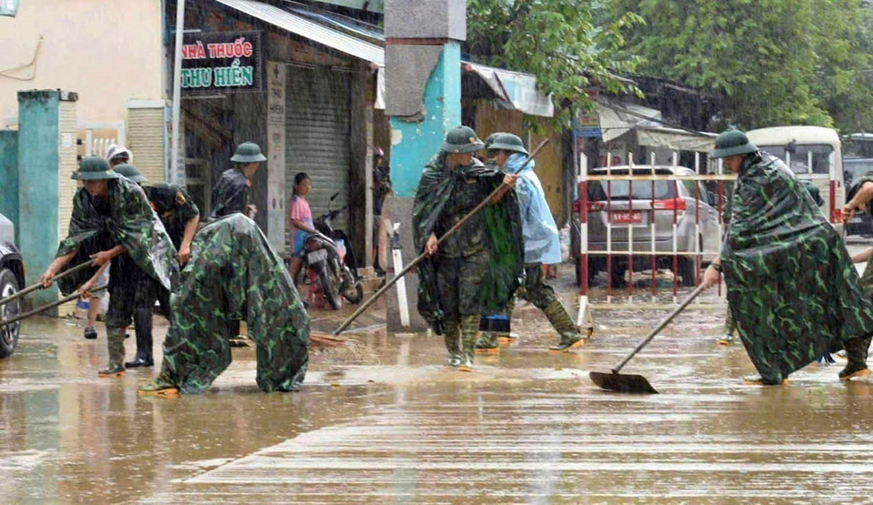Military personnel help residents clean up and restore the environment following the floods. (Photo: VNA)