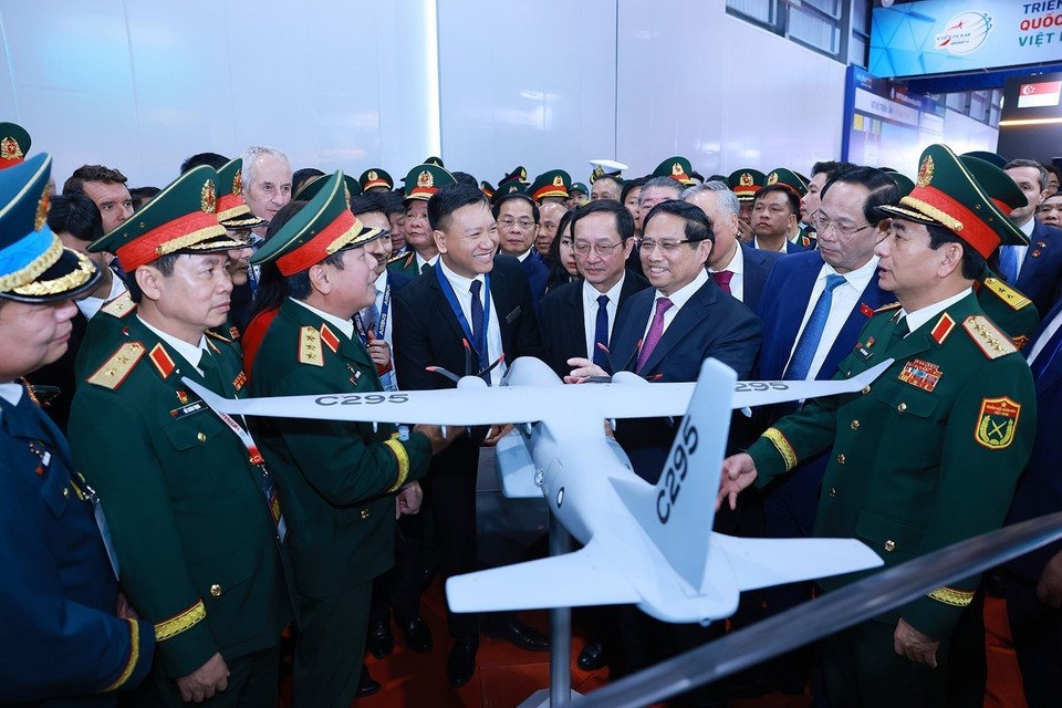 The PM and other delegates contemplate the weapons and equipment display at the Vietnam International Defense Exhibition 2024. Photo: VNA