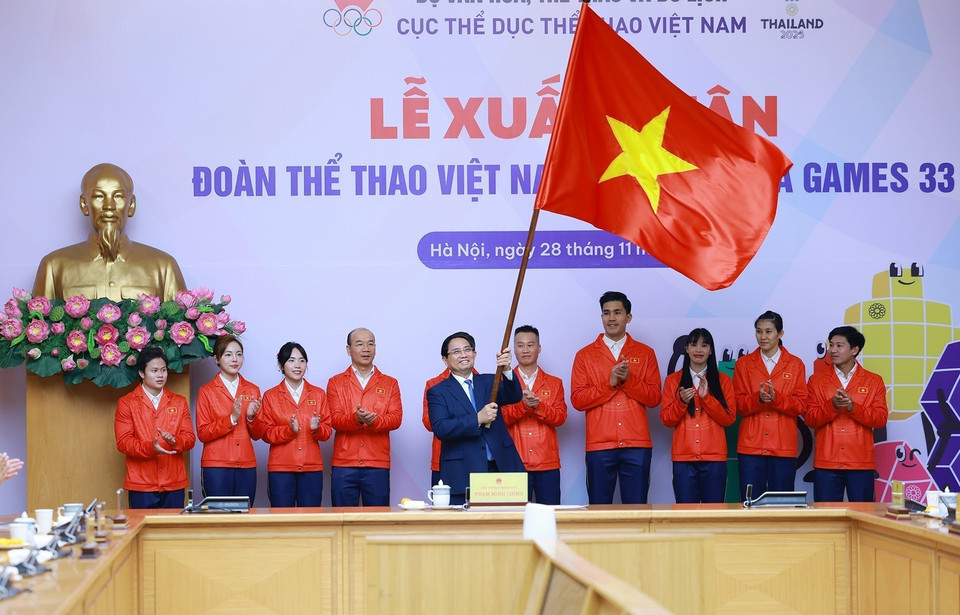 Prime Minister Pham Minh Chinh presents the flag to the Vietnamese sports delegation heading to the 33rd SEA Games. (Photo: VNA)