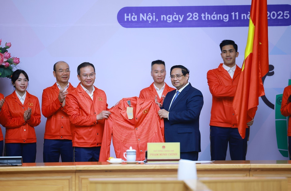 The Vietnamese sports delegation competing at the 33rd SEA Games presents competition attire to Prime Minister Pham Minh Chinh. (Photo: /VNA)