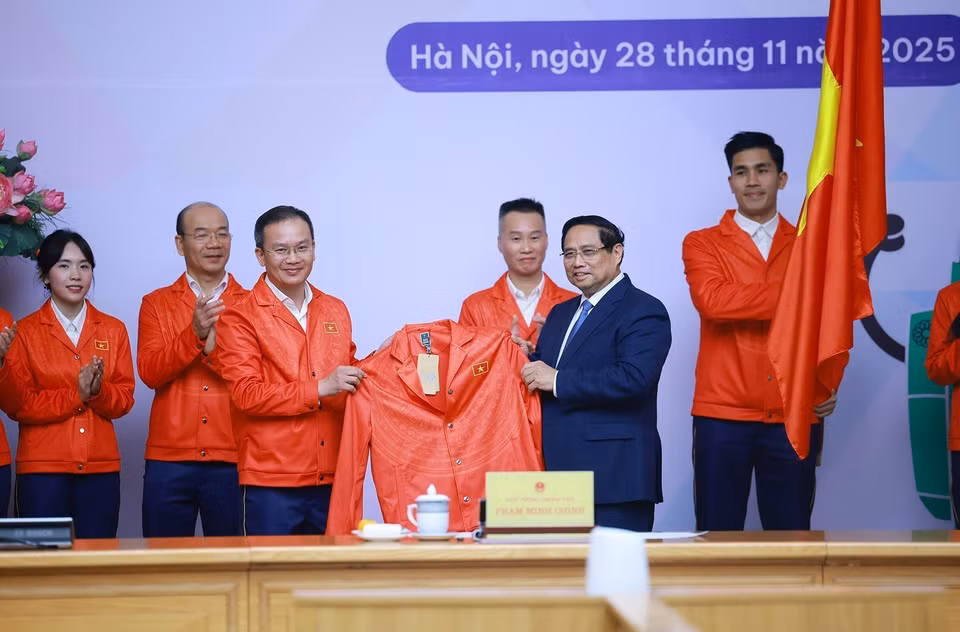 The Vietnamese sports delegation competing at the 33rd SEA Games presents competition attire to Prime Minister Pham Minh Chinh. (Photo: /VNA)