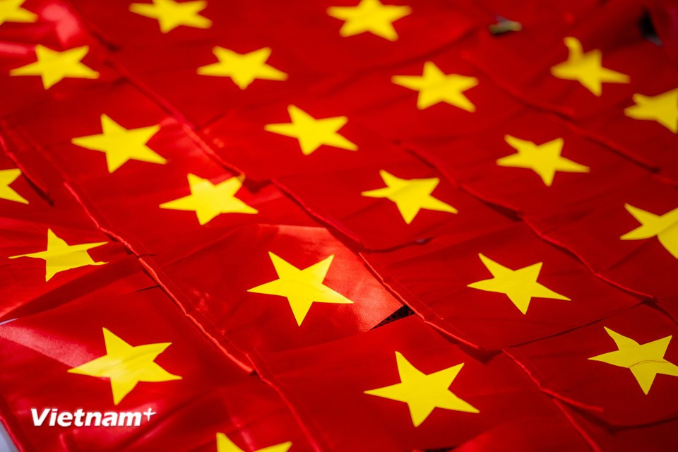 National flags, made with skill and care, help brighten the country in the vibrant red of the festive season. (Photo: Vietnam+)
