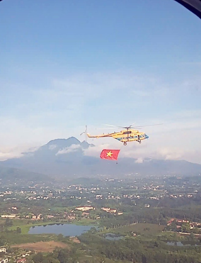 Mi-171 helicopter carries flag ahead of formation training flight. (Photo: VNA)