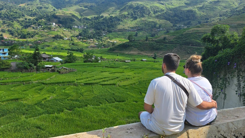 Foreign tourists enjoy the sight of Ta Van’s verdant rice fields. (Photo: VNA)