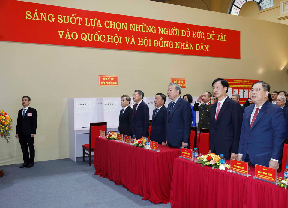Party General Secretary To Lam, delegates and voters perform the flag-salute ceremony marking the opening of the election at Polling Station No. 02 in Ba Dinh ward, Hanoi. (Photo: VNA)