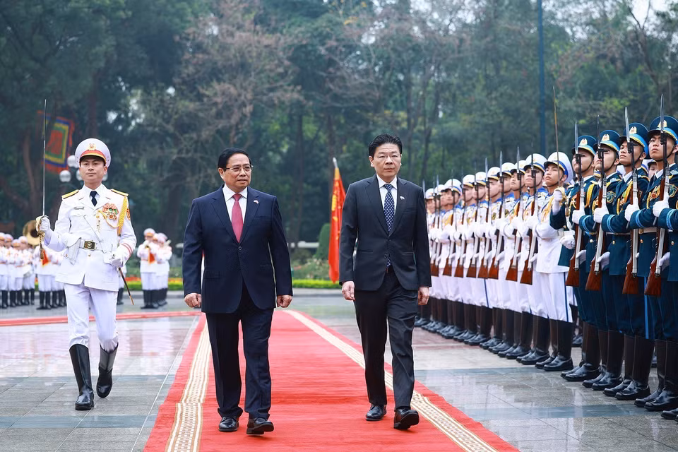 Prime Minister Pham Minh Chinh and Singaporean Prime Minister Lawrence Wong review the Honor Guard of the Vietnam People's Army. (Photo: VNA)