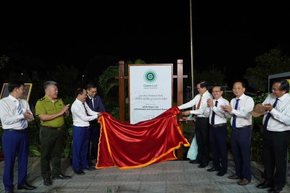 Delegates remove the Green List emblem displayed in the grounds of the Con Dao National Park's management board. (Photo: VNA)
