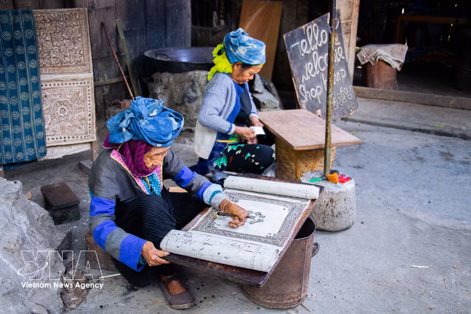 Applying beeswax patterns to the fabric before indigo dyeing (Photo: VNA)