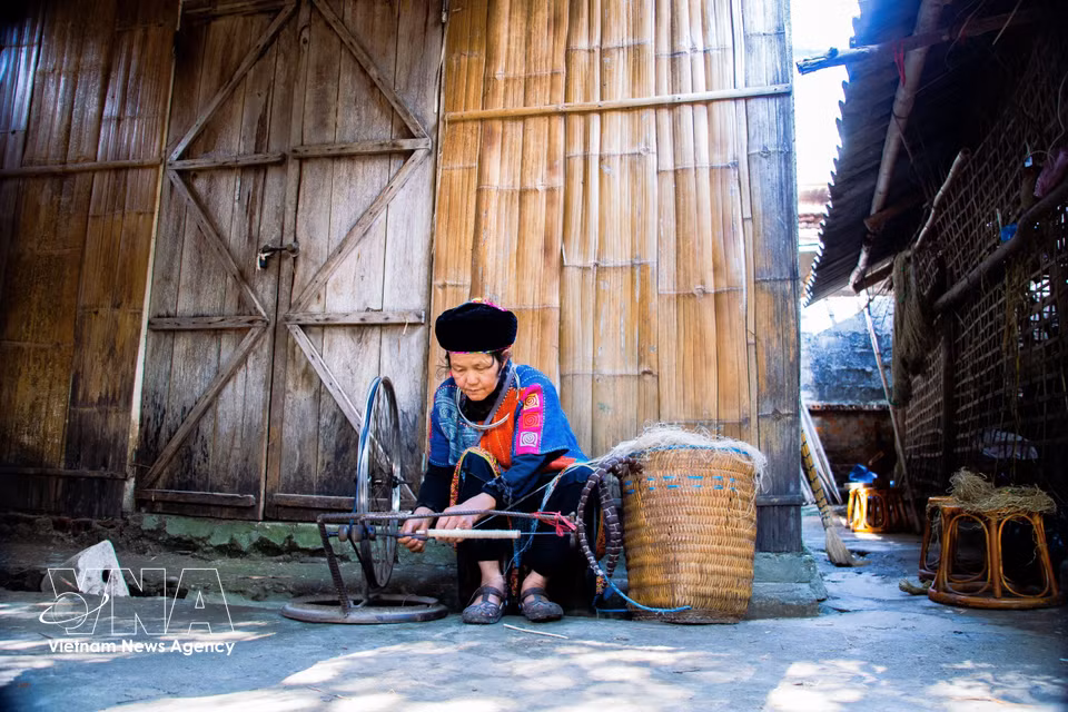A local artisan spins hemp fibres on her porch, the first step in a hand-weaving process passed down through generations. (Photo: VNA)