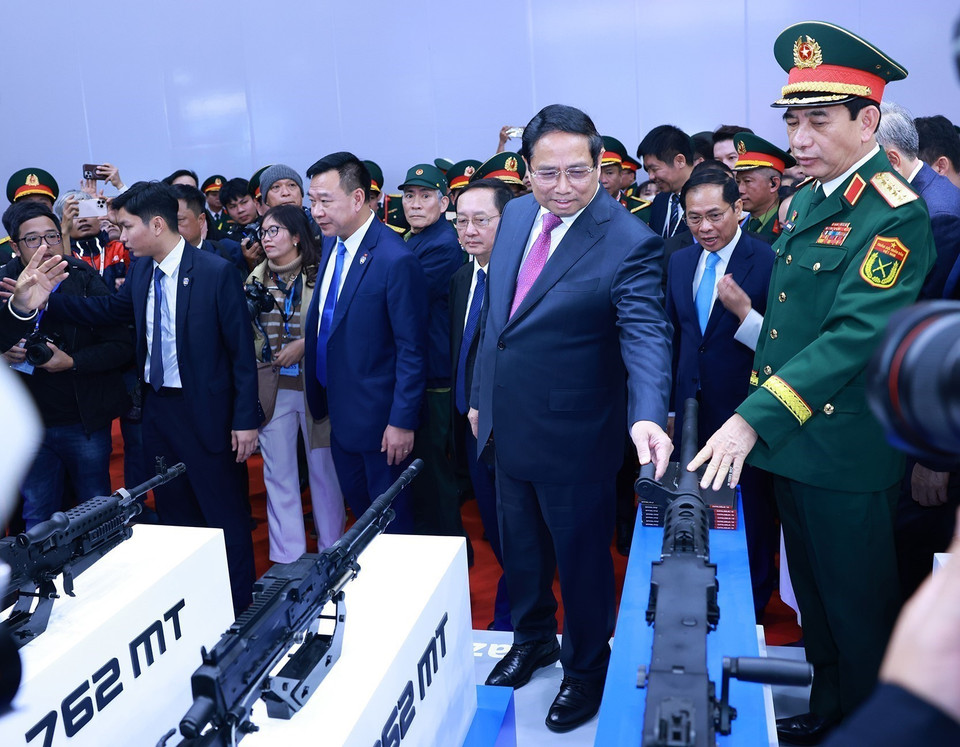 The PM and other delegates contemplate the weapons and equipment display at the Vietnam International Defense Exhibition 2024. Photo: VNA