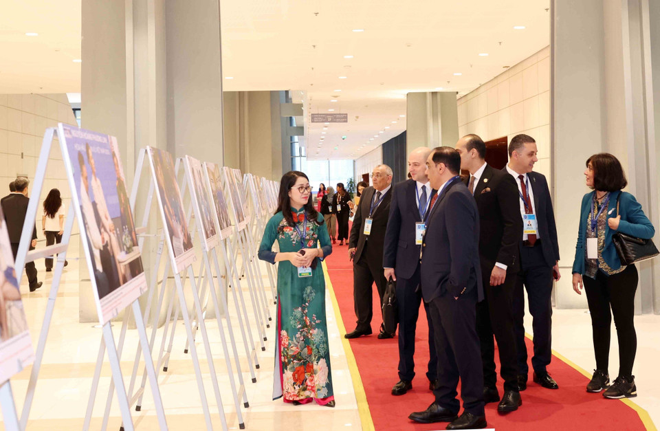 International delegates visit the Vietnam News Agency photo exhibition at the Hanoi Convention signing ceremony on the morning of October 25. (Photo: VNA)