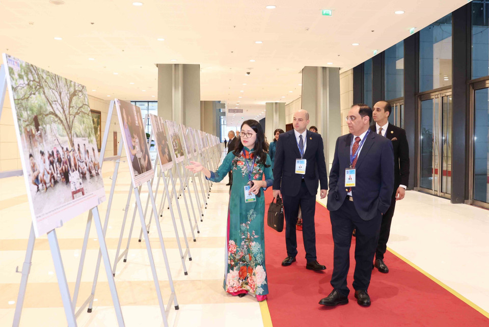 International delegates visit the Vietnam News Agency photo exhibition at the Hanoi Convention signing ceremony on the morning of October 25. (Photo: VNA)