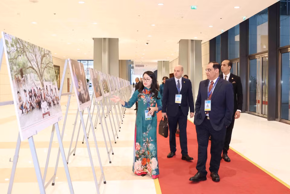 International delegates visit the Vietnam News Agency photo exhibition at the Hanoi Convention signing ceremony on the morning of October 25. (Photo: VNA)