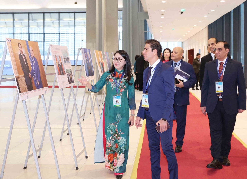 International delegates visit the Vietnam News Agency photo exhibition at the Hanoi Convention signing ceremony on the morning of October 25. (Photo: VNA)