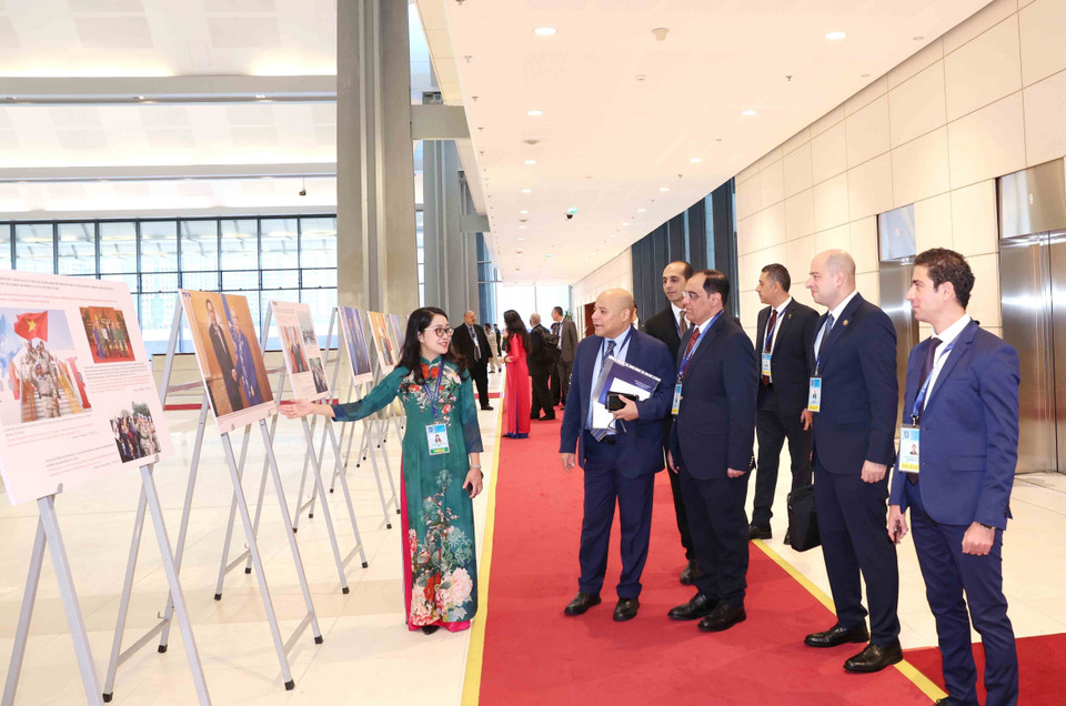 International delegates visit the Vietnam News Agency photo exhibition at the Hanoi Convention signing ceremony on the morning of October 25. (Photo: VNA)