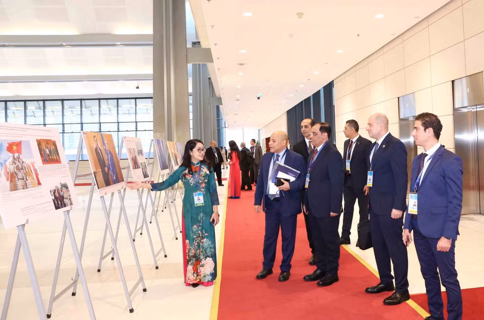 International delegates visit the Vietnam News Agency photo exhibition at the Hanoi Convention signing ceremony on the morning of October 25. (Photo: VNA)