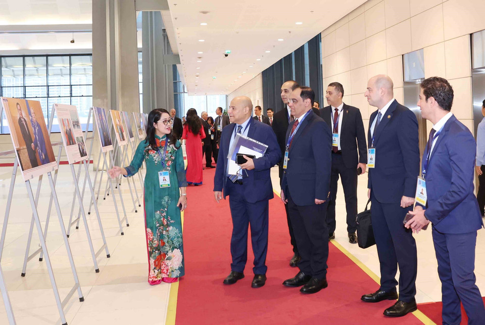 International delegates visit the Vietnam News Agency photo exhibition at the Hanoi Convention signing ceremony on the morning of October 25. (Photo: VNA)