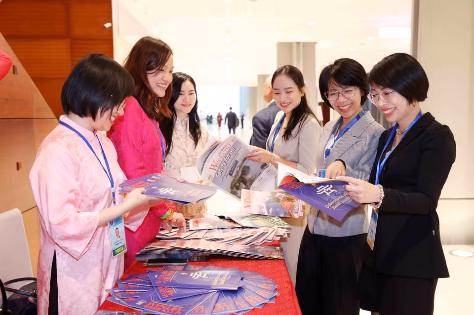 Delegates attending the ceremony learn about the Vietnam News Agency’s publications. (Photo: VNA)