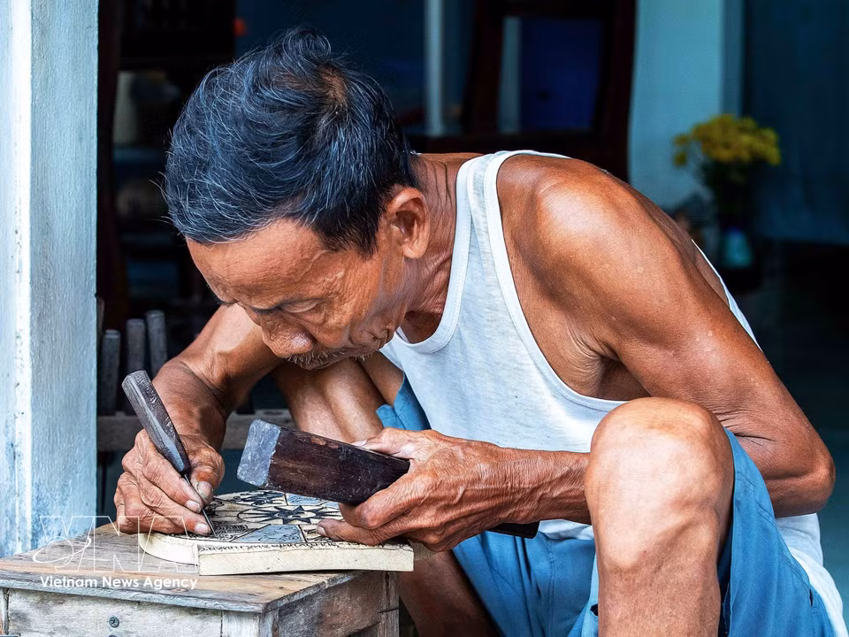 Artisan Ky Huu Phuoc, 77, is a ninth-generation heir to a family of Sinh village painters. (Photo: VNA)
