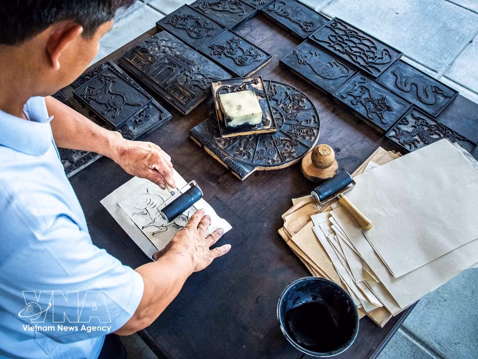 From the carved woodblocks, artisans use black ink made from burnt straw ash and leaves to print evenly onto the paper. (Photo: VNA)