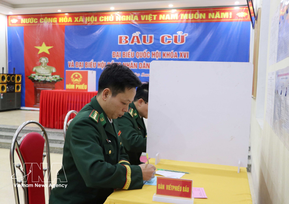 Voters select their preferred candidates before casting their ballots. (Photo: VNA)