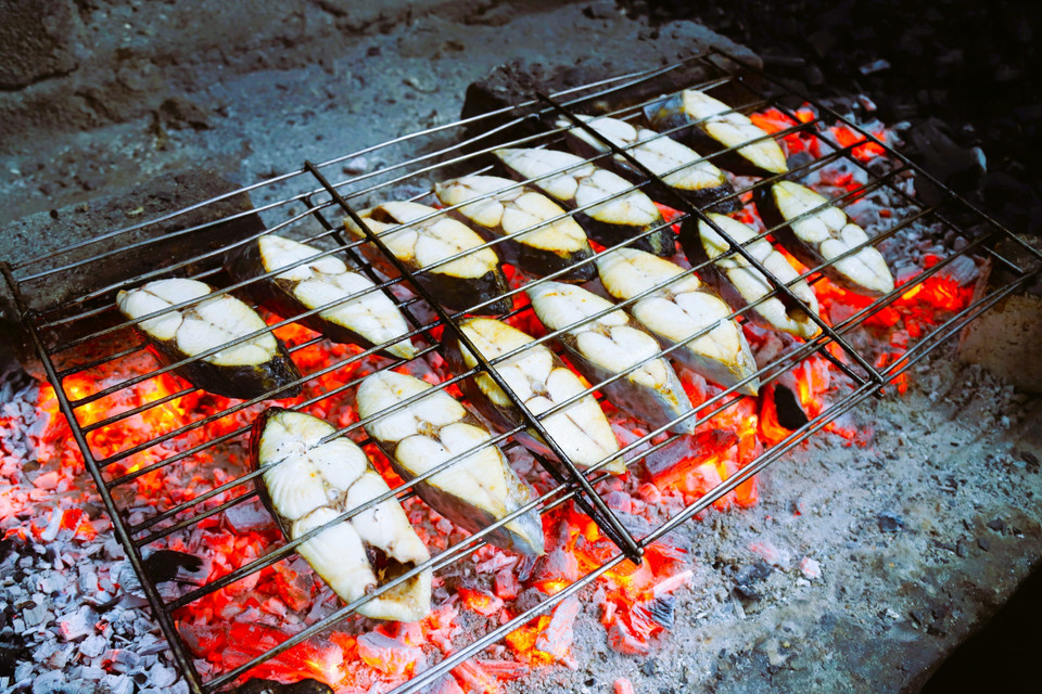 After being cleaned and naturally air-dried, mackerel are evenly laid on metal racks and grilled over layers of red-hot charcoal. Each rack is firmly woven from thin iron rods, about 30 cm wide and 75 cm long. (Photo: VNA)