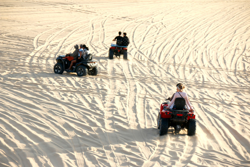 Visitors ride off-road vehicles across the sand dunes at Bau Trang. (Photo: VNA)