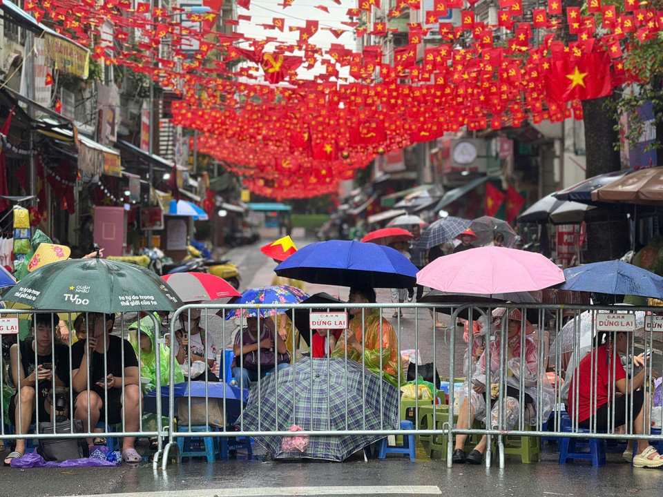 Hanoians endure the weather, patiently waiting and cheering for the armed forces. (Photo: VNA)