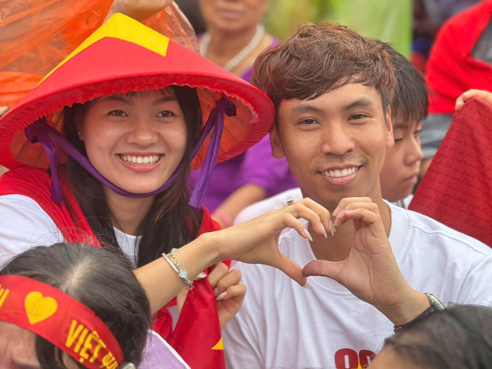 Love and pride outweigh the rain. A moment capturing Hanoians enduring the weather, patiently waiting and cheering for the armed forces. (Photo: VNA)