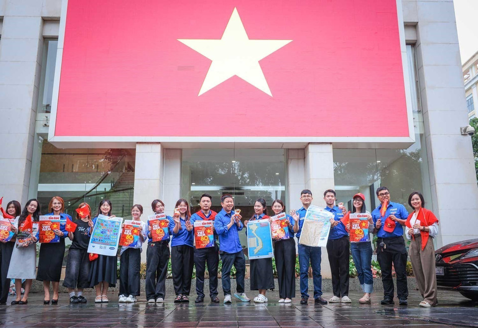 Young people check in at VNA headquarters with a giant national flag. (Photo: VNA)
