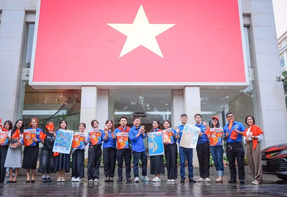 Young people check in at VNA headquarters with a giant national flag. (Photo: VNA)