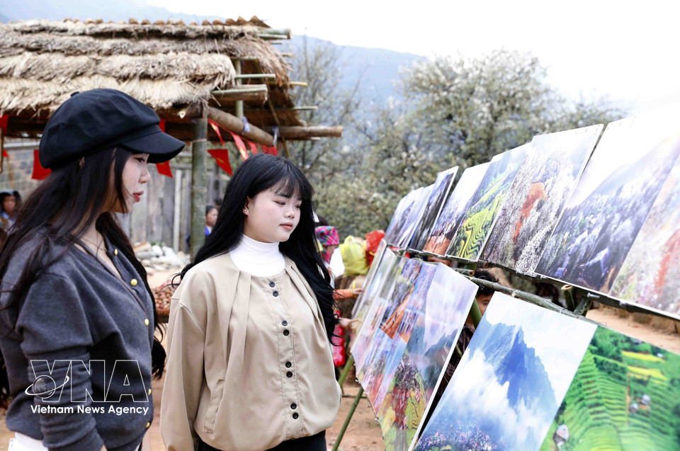 Visitors explore a photo exhibition at the event. (Photo: VNA)