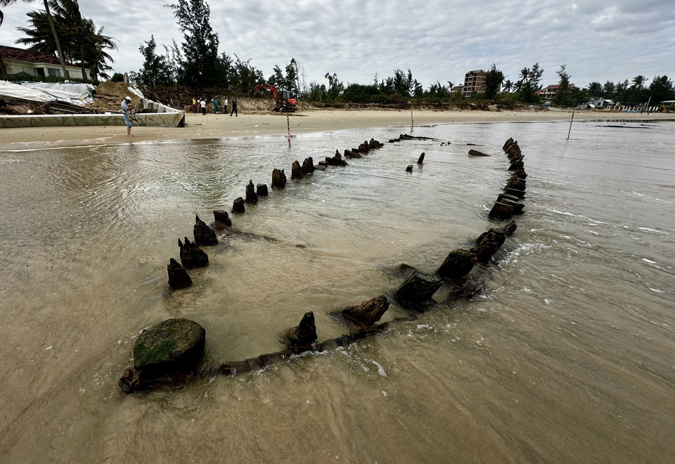 According to local residents, the ship first surfaced in 2023 before being buried again under sand. Upon its reappearance, city authorities promptly cordoned off the site, secured the area, and began verifying its origin. (Photo: VNA)