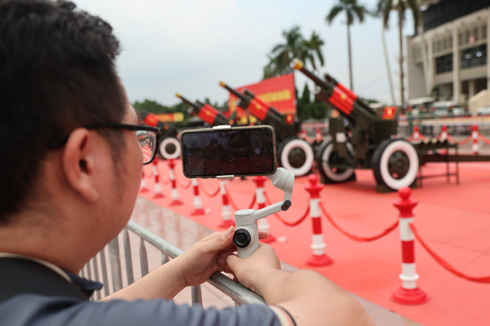 A visitor uses professional equipment to photograph the solemn artillery display. (Photo: VNA)