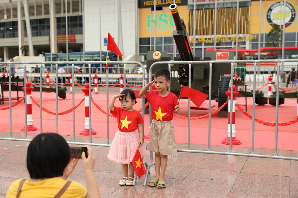 Children pose with national flags in front of the artillery battery. (Photo: VNA)