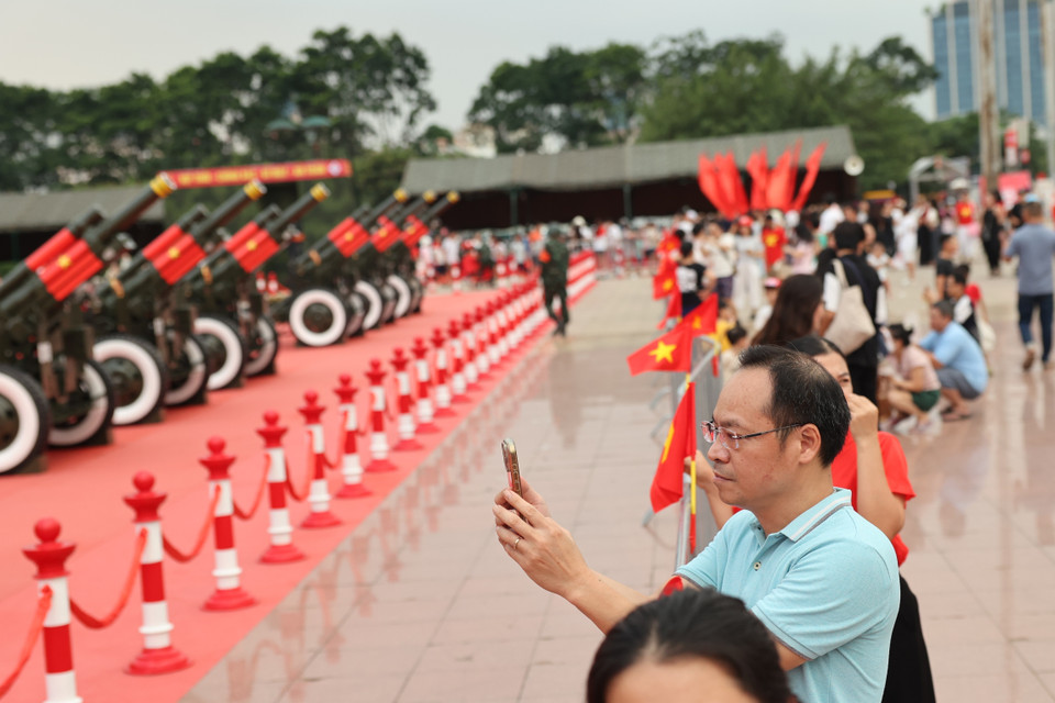 Residents and visitors capture memorable moments with the ceremonial artillery. (Photo: VNA)