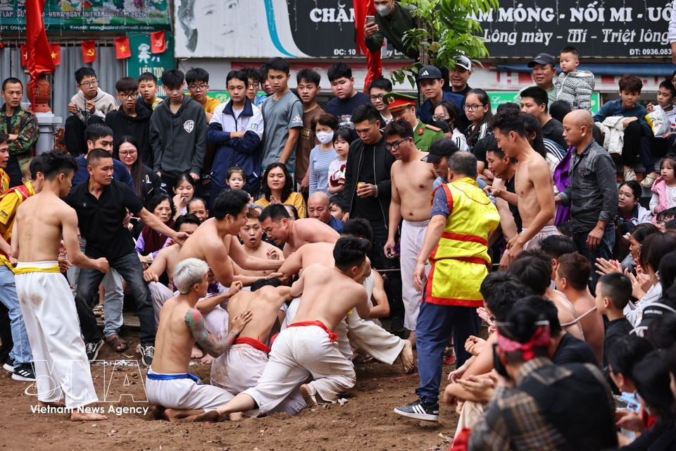 Spectators watch in suspense as players compete fiercely for the ball at the Thuy Linh communal house yard. (Photo: VNA)
