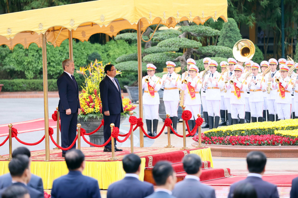 Prime Minister Pham Minh Chinh and Kyrgyz Prime Minister Adylbek Kasymaliev listen to the national anthems of both countries. (Photo: VNA)