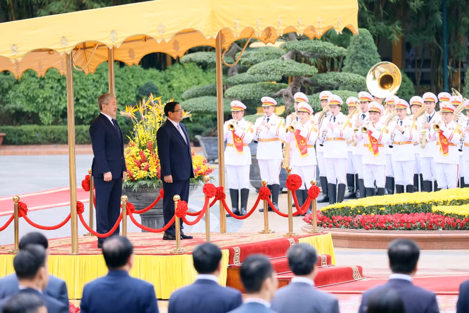 Prime Minister Pham Minh Chinh and Kyrgyz Prime Minister Adylbek Kasymaliev listen to the national anthems of both countries. (Photo: VNA)