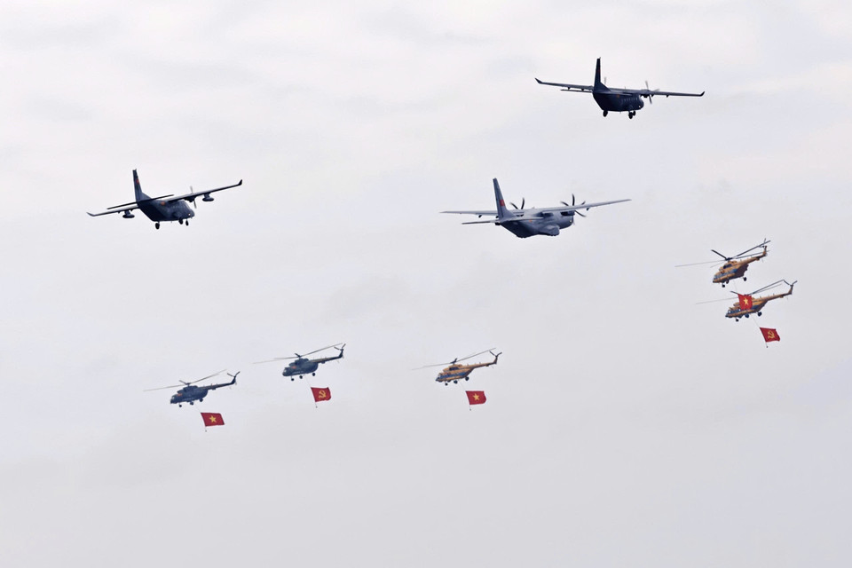 Formation of Mi-171, Mi-17 and Mi-8 helicopters carrying Party and national flags, together with three Casa C-295 and C-212i transport aircraft, passes over Ba Dinh Square. (Photo: VNA)
